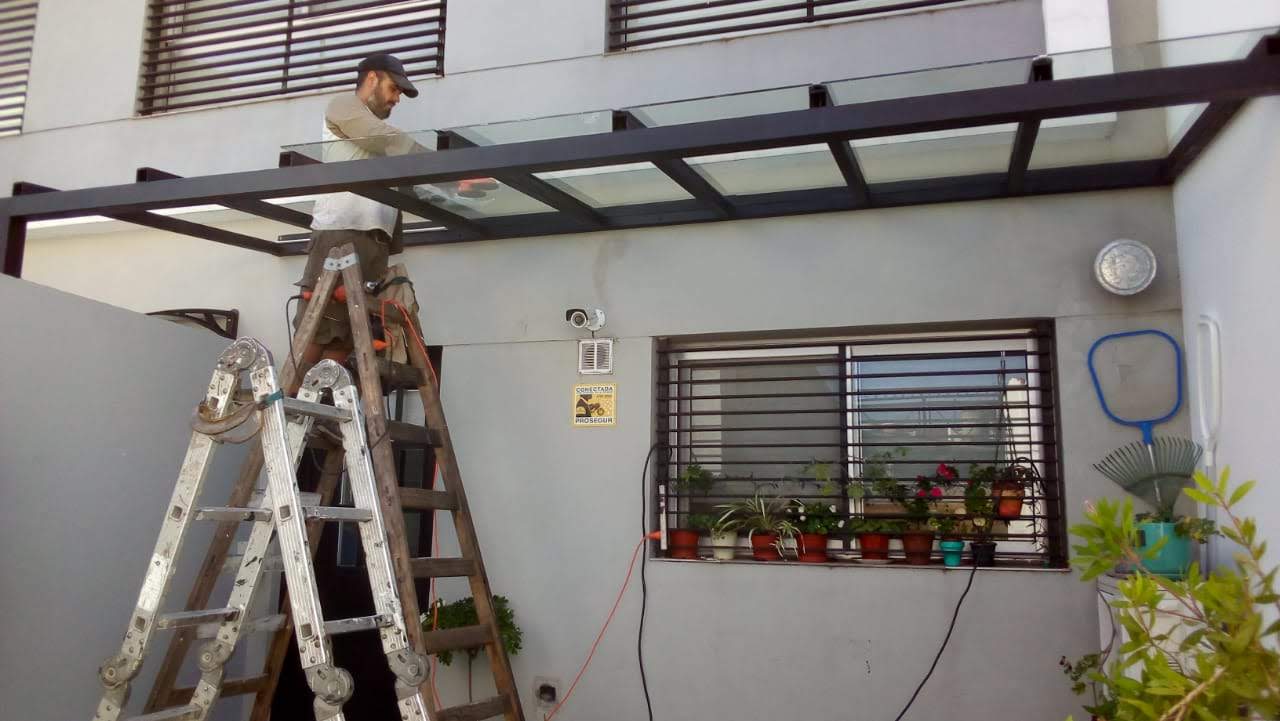 COLOCACIÓN DE VIDRIOS LAMINADOS SOBRE BURLETERÍA DE GOMA MONTADA SOBRE LA ESTRUCTURA TUBULAR DE HIERRO.